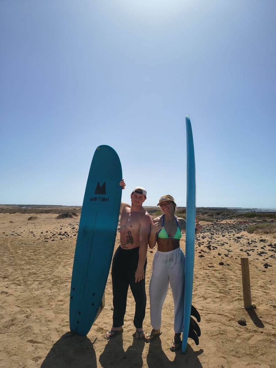 Two surf students with soft-top boards on the beach in Fuerteventura
