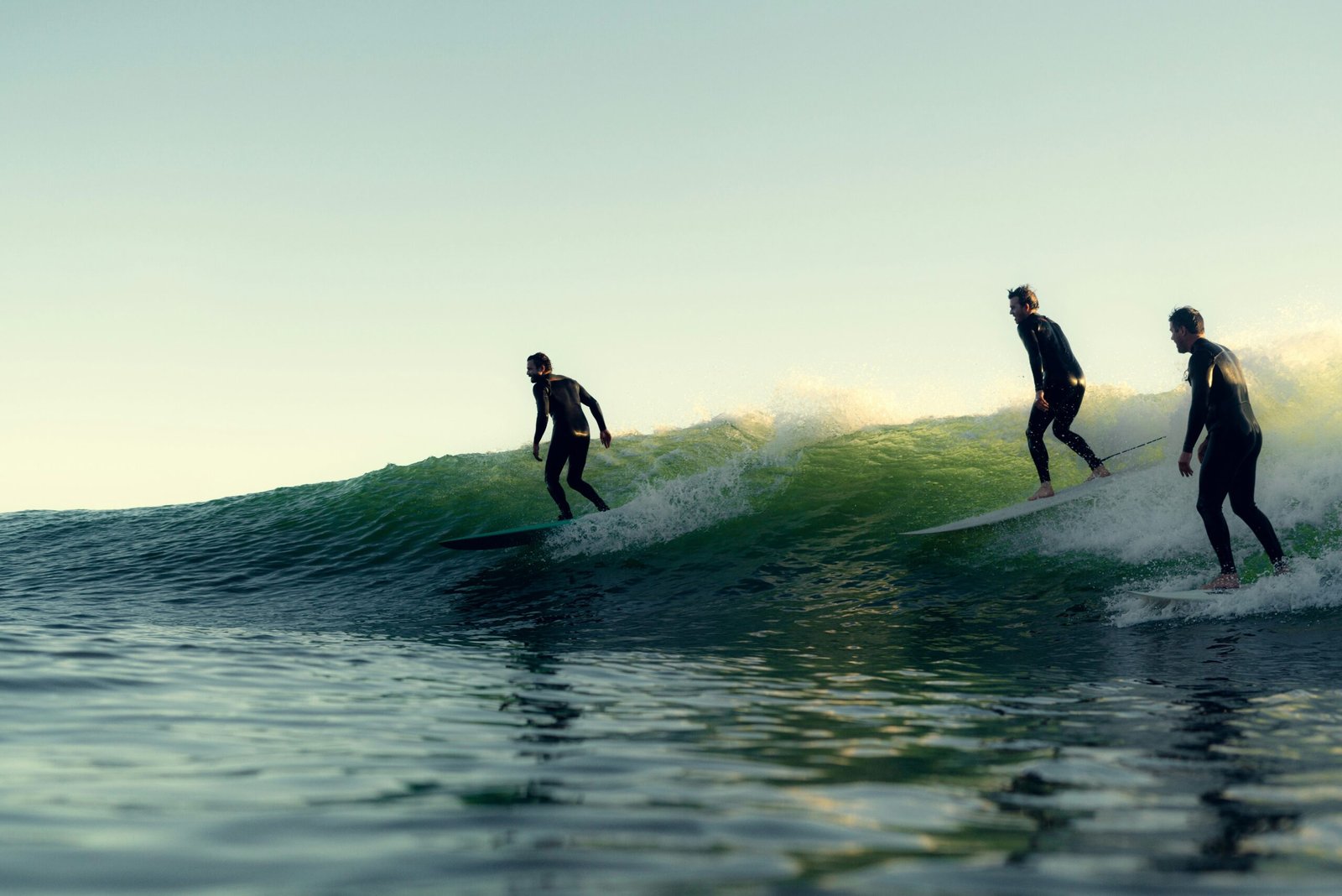 Three surfers riding the same wave – group surf lessons in Corralejo