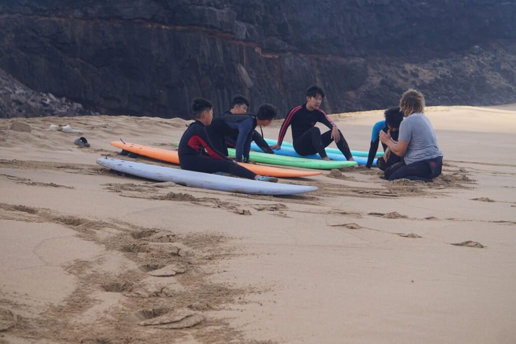 Group surf lesson warm-up on the sand with soft-top boards, Fuerteventura