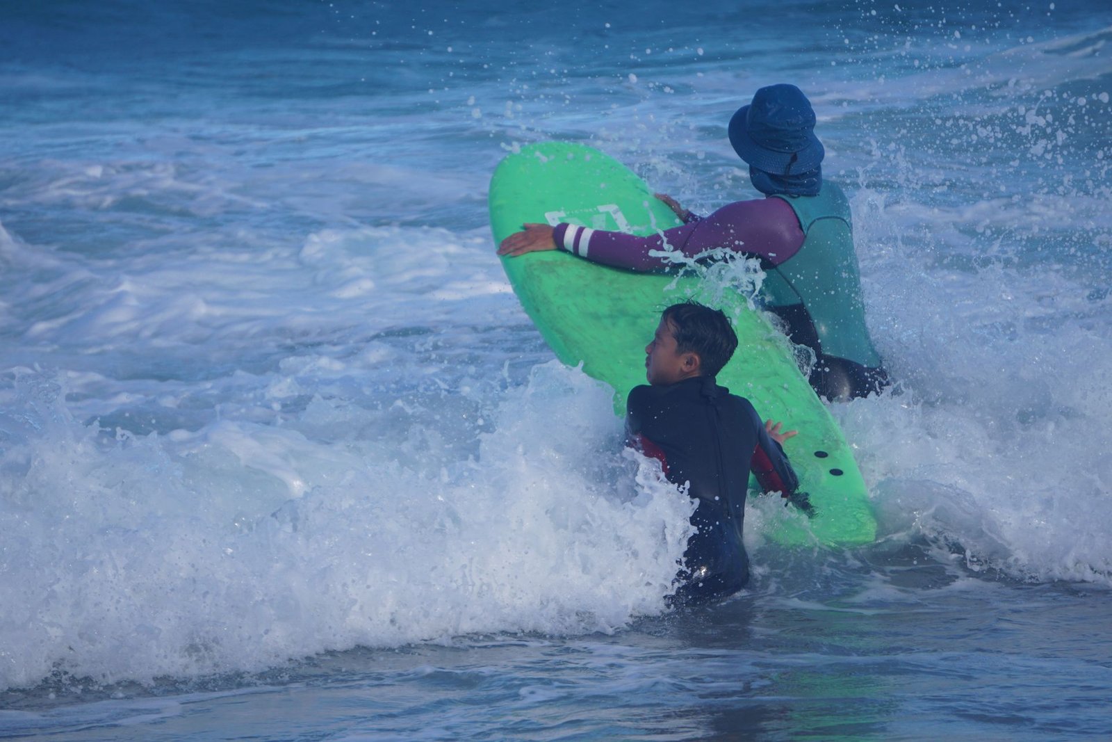 Surf instructor pushing a student into a wave – private surf lessons in Corralejo