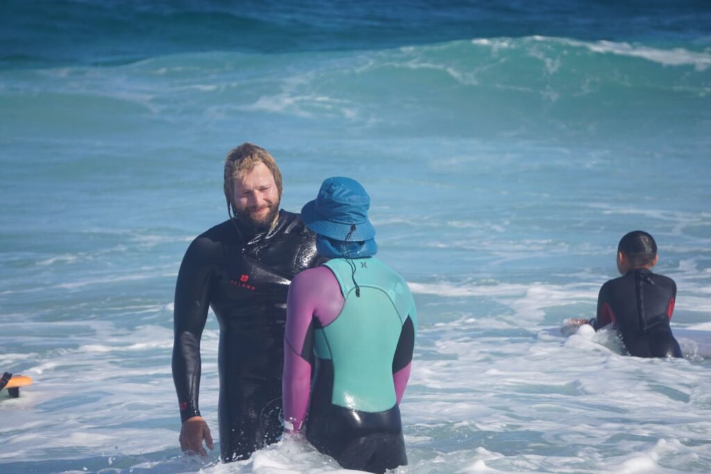 Surf instructors in the water with students during a group surf lesson