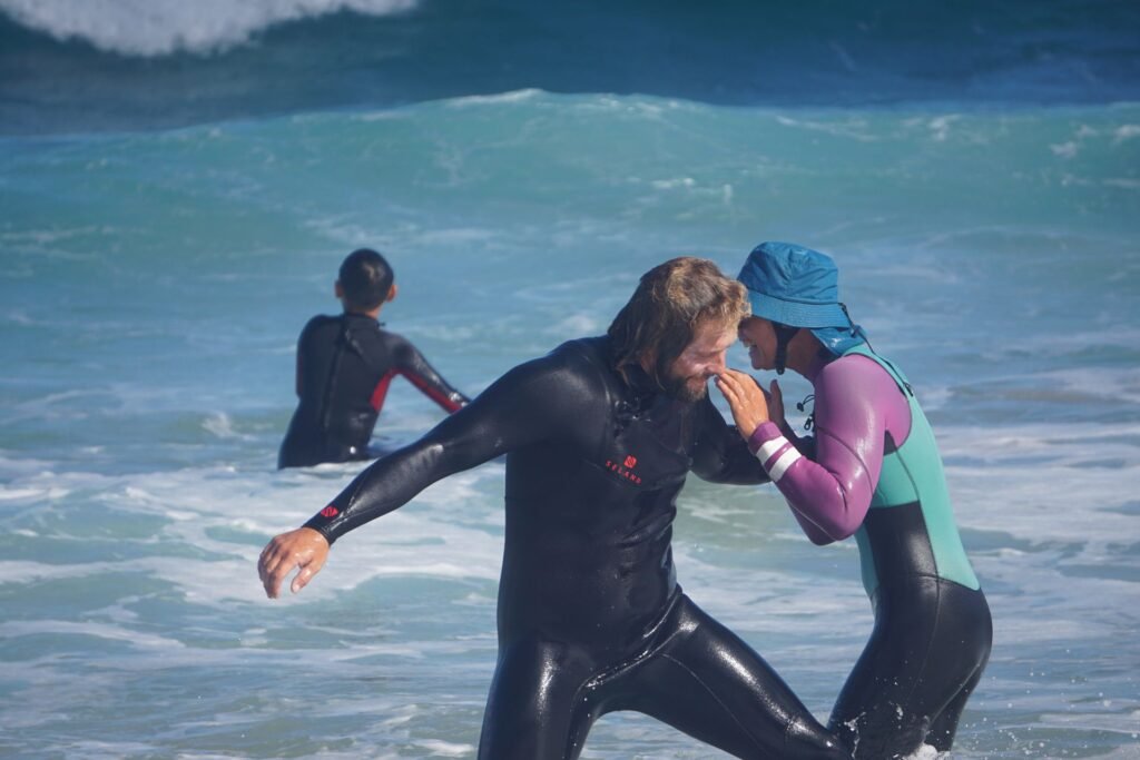 Surf instructors laughing together in the water during a lesson in Fuerteventura