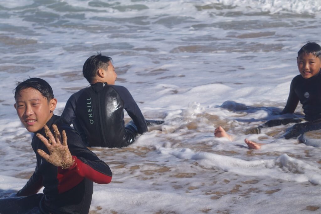 Kids having fun in the shore break during a surf lesson in Fuerteventura