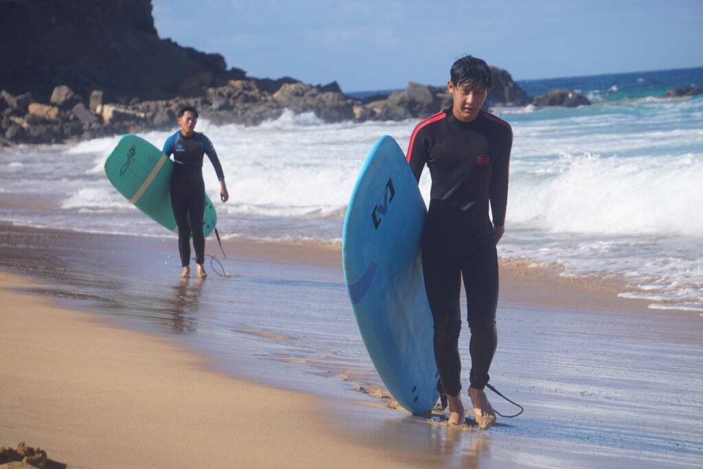 Surf students walking out of the sea with their boards, Fuerteventura