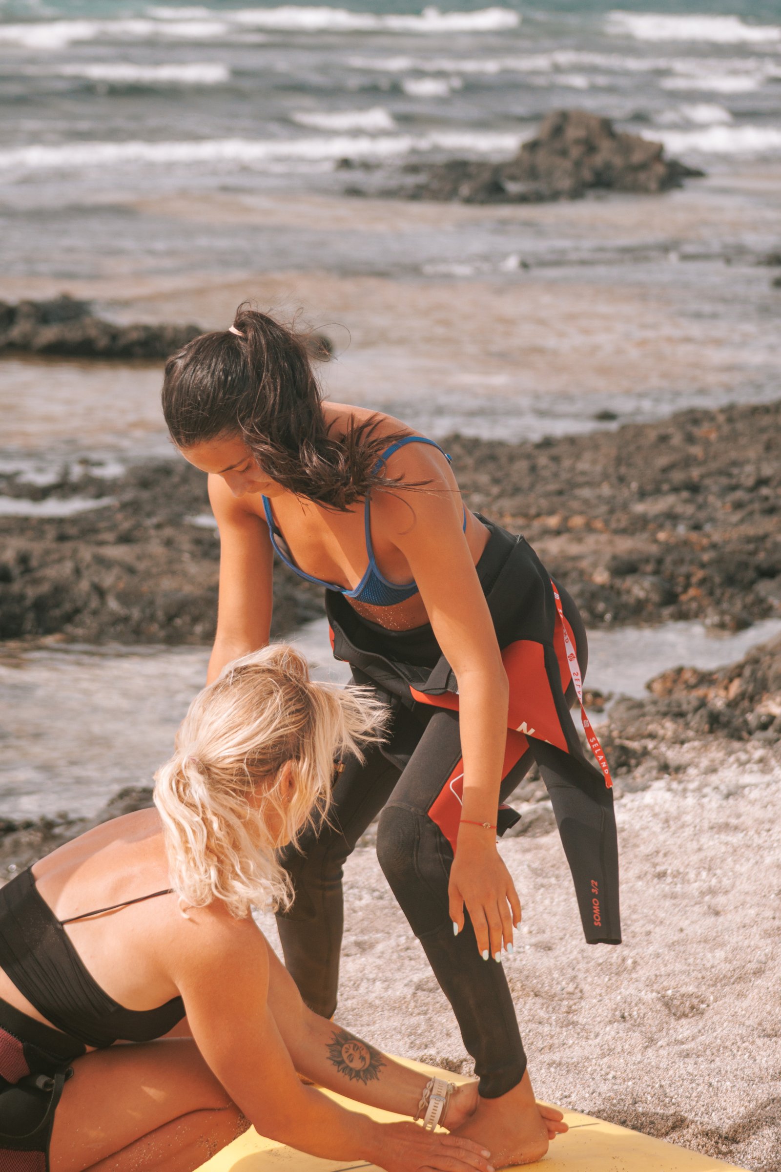 Surf instructor correcting a student's stance during a beginner surf lesson
